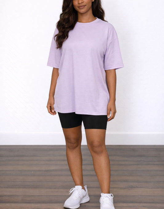 Woman wearing a light purple Oversized T-Shirt and black shorts on a white background.