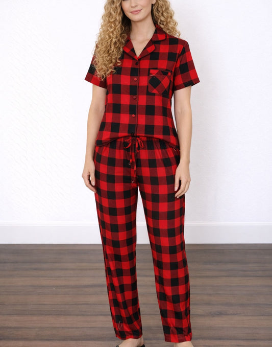 Woman wearing matching red and black checkered pajama shirt and pajama pants set.