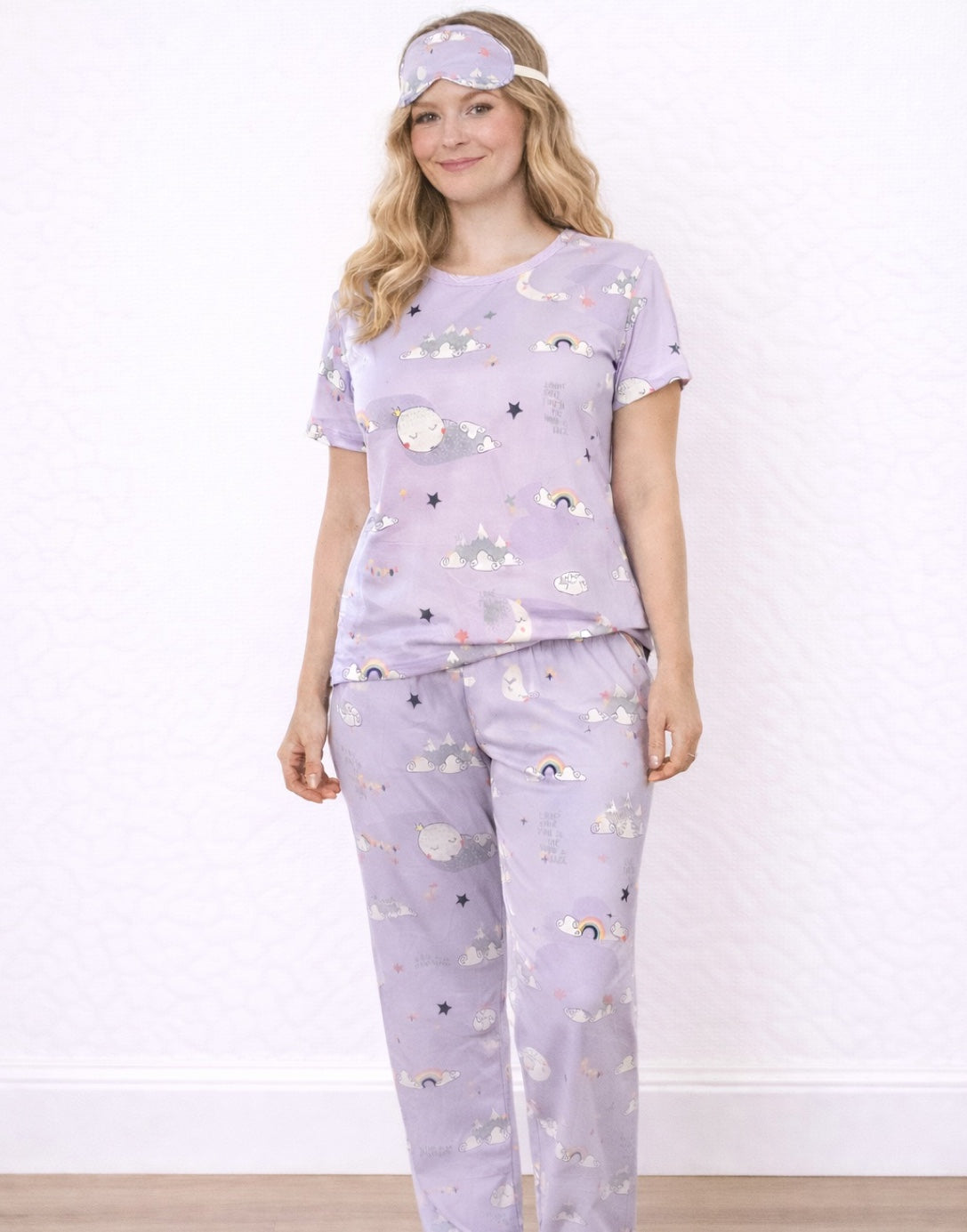 Woman wearing a purple Pajama Set and Eye Cover with cloud and moon patterns on a white background