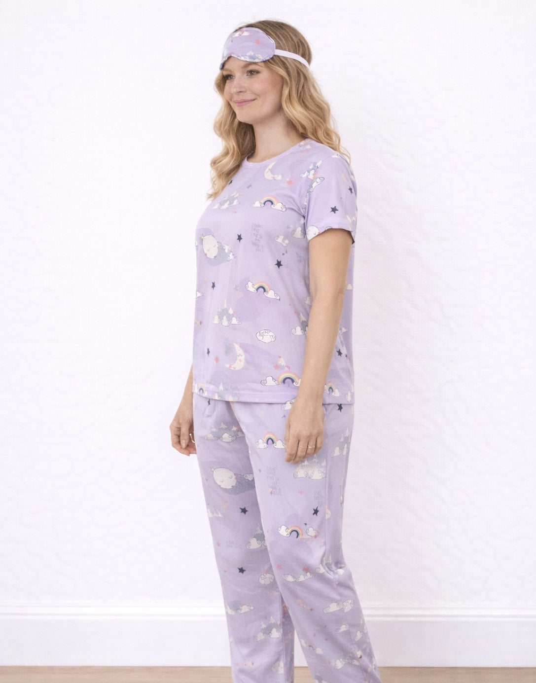 Side view of woman wearing a purple Pajama Set and Eye Cover with cloud and moon patterns on a white background. 