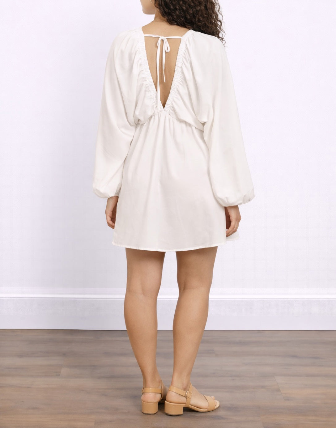 Back view of woman wearing a white Plunging Neck Lantern Sleeve Smock Dress against a plain background.