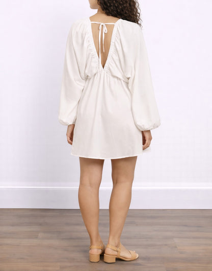Back view of woman wearing a white Plunging Neck Lantern Sleeve Smock Dress against a plain background.