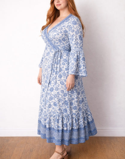 Side view of woman wearing a blue floral Plus Size Bell Sleeve Wrap Maxi Dress against a white background.