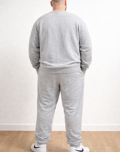 Back view of person wearing a gray tracksuit with Plus Size Drawstring Jogger Pants and white sneakers on a plain background.