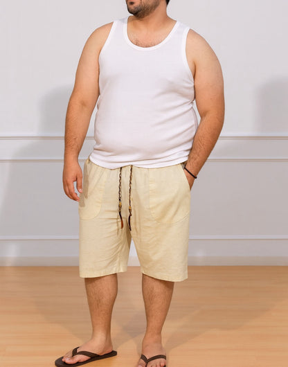 Person wearing white tank top and cream color Plus Size Drawstring Knee Length Shorts with plain background and wood flooring.