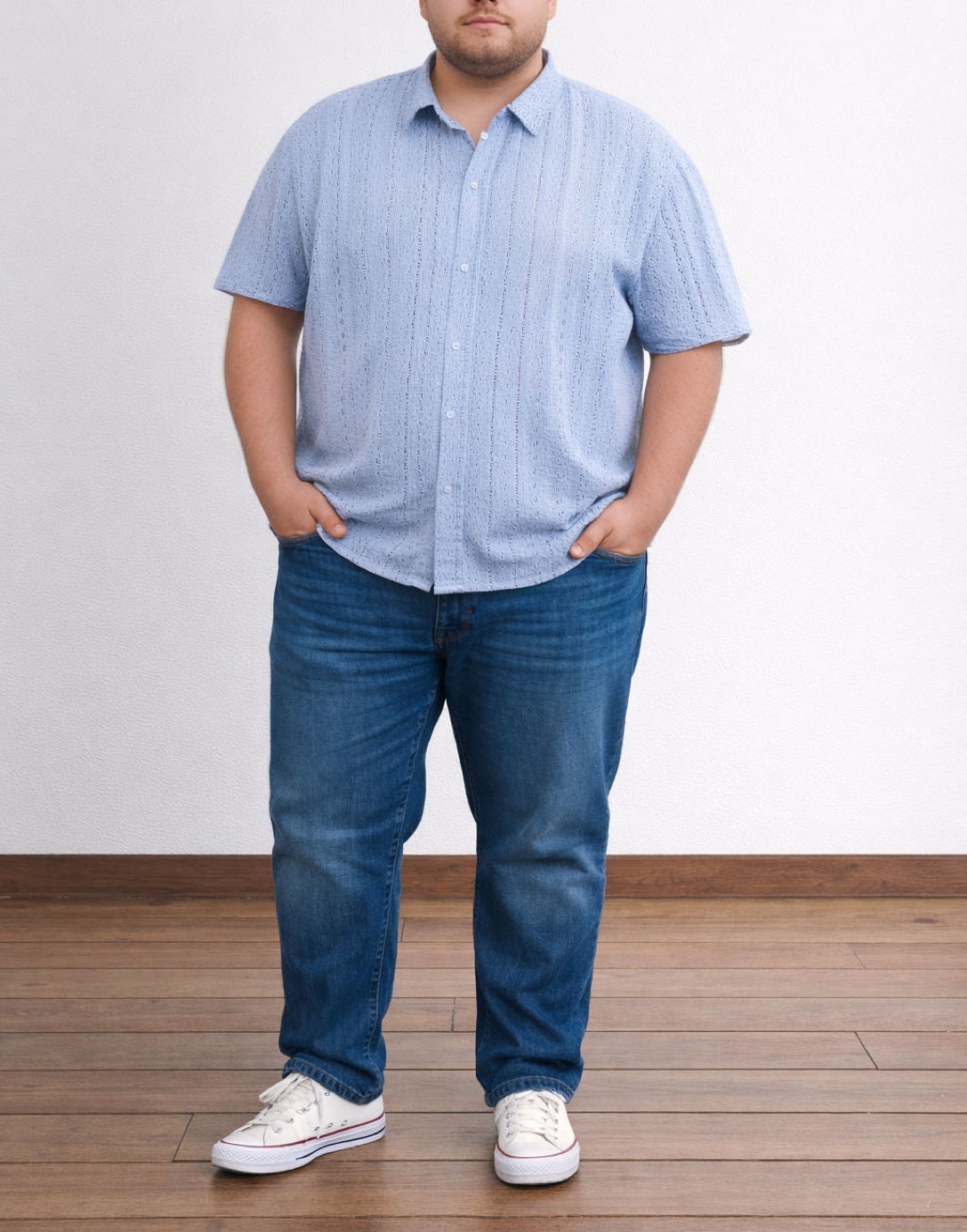 Person wearing a blue Plus Size Drop Shoulder Loose Fit Button Down Shirt and jeans standing on a wooden floor with a white wall background.