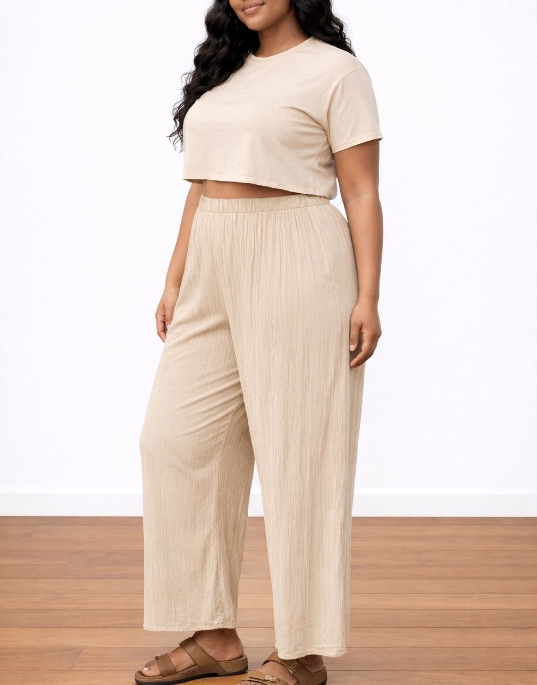 Side view of woman wearing a beige top and Plus Size Wide Leg Pants on a white background.