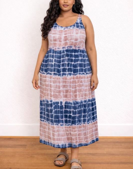 Woman wearing a tie-dye Plus Size Tank Dress with blue and pink patterns against a white wall.