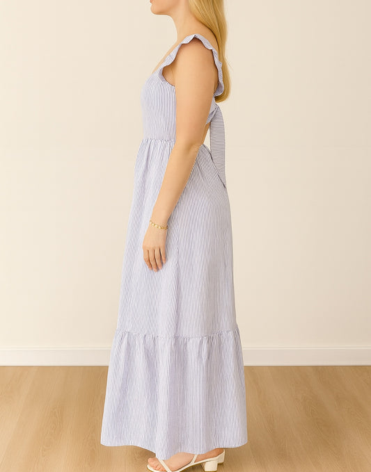 Side view of Woman wearing a blue and white striped Square Neck Ruffled Sleeve Maxi Dress against a beige background.