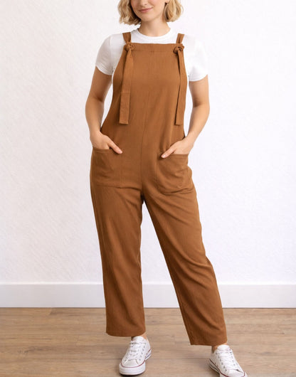 Woman wearing brown Tie Detail Pocket Overall Jumpsuit against a white background.