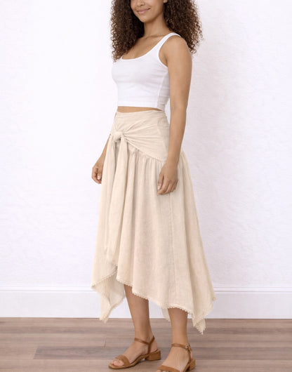 Side view of woman wearing a white top and beige Tie Front Asymmetrical Hem Skirt on a plain background.