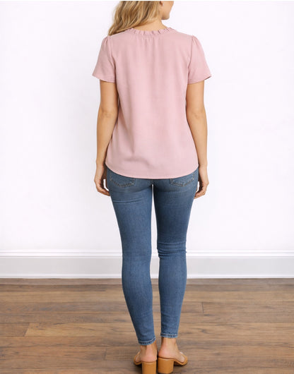 Back view of woman wearing a pink Tie Neck Puff Sleeve Blouse and blue jeans on a white background.
