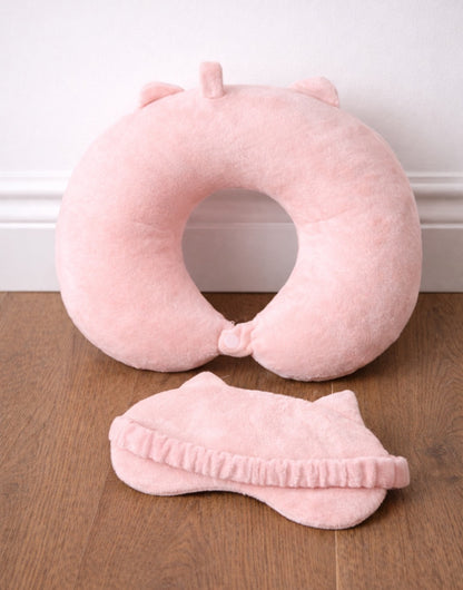 Back view of pink Travel Pillow and Eye Mask on a wooden floor.
