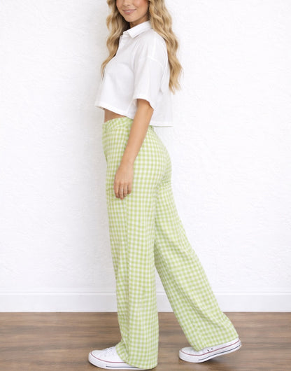 Side view of woman wearing a white cropped top and green checkered Wide Leg High Waist Pants against a white background.