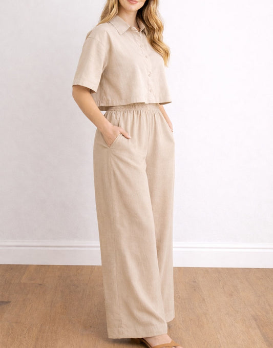 Side view of woman wearing a beige shirt and Wide Leg Pocket Pants against a white wall.