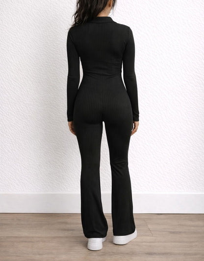 Back view of woman wearing a black Flare Leg Jumpsuit with a white background.